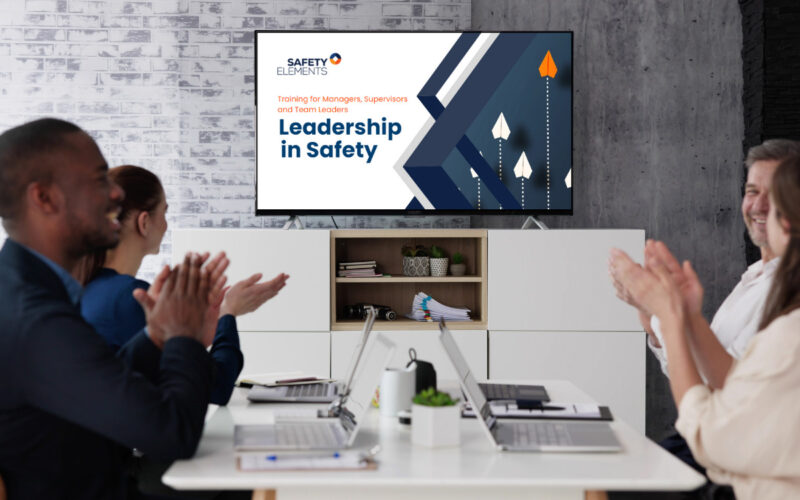 A team of managers participating in a "Leadership in Safety" training session, engaging in discussions on workplace safety, risk management, and fostering a strong safety culture.